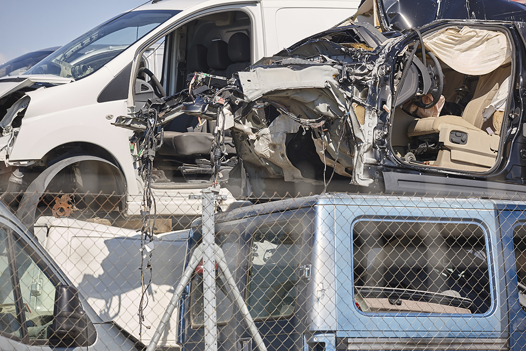 Car scrapyard. Stacked damaged vehicles ready to be recycling. W