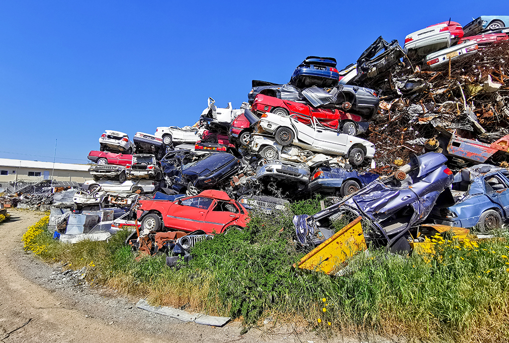 Pile of various scrap cars and other metals on a junk yard ready recycling industry.
